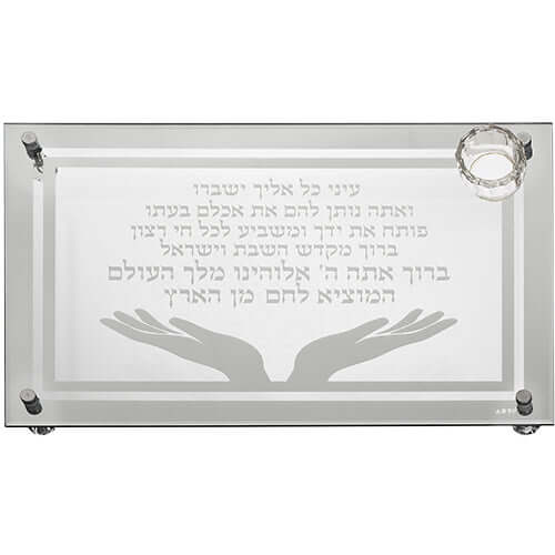 מגש חלה זכוכית עבה עם חריטה של ברכת "המוציא לחם מן הארץ" וקטע תהילים, עיטור זוג ידיים פתוחות ומוביל קטן למלח בפינה.