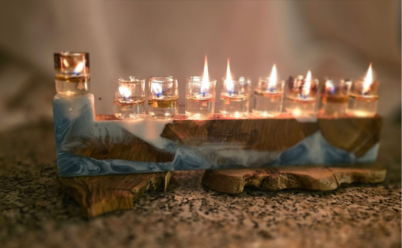 חנוכיית שמן בעבודת יד מעץ זית בשילוב אפוקסי בגווני כחול ולבן עם כוסיות שמן דולקות