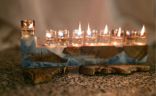 חנוכיית שמן בעבודת יד מעץ זית בשילוב אפוקסי בגווני כחול ולבן עם כוסיות שמן דולקות