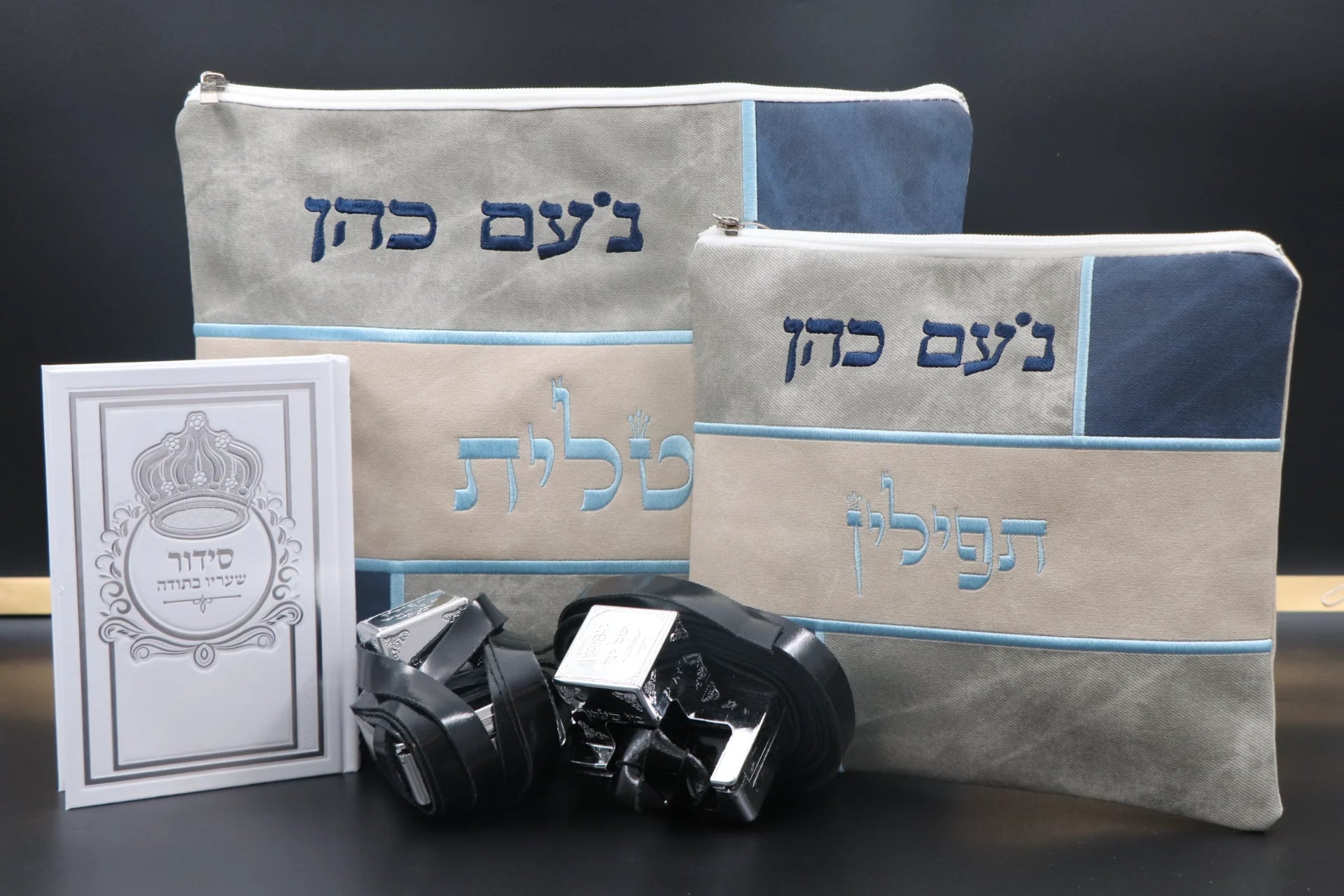 סט בר מצווה בצבעי אפור כחול הכולל תיק טלית גדול, תיק תפילין, זוג תפילין שחורים וסידור תפילה בעיצוב מודרני על רקע כהה