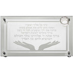 מגש חלה זכוכית עבה עם חריטה של ברכת "המוציא לחם מן הארץ" וקטע תהילים, עיטור זוג ידיים פתוחות ומוביל קטן למלח בפינה.

